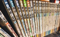 遺品整理のシーンで本棚に並ぶ雑誌や本