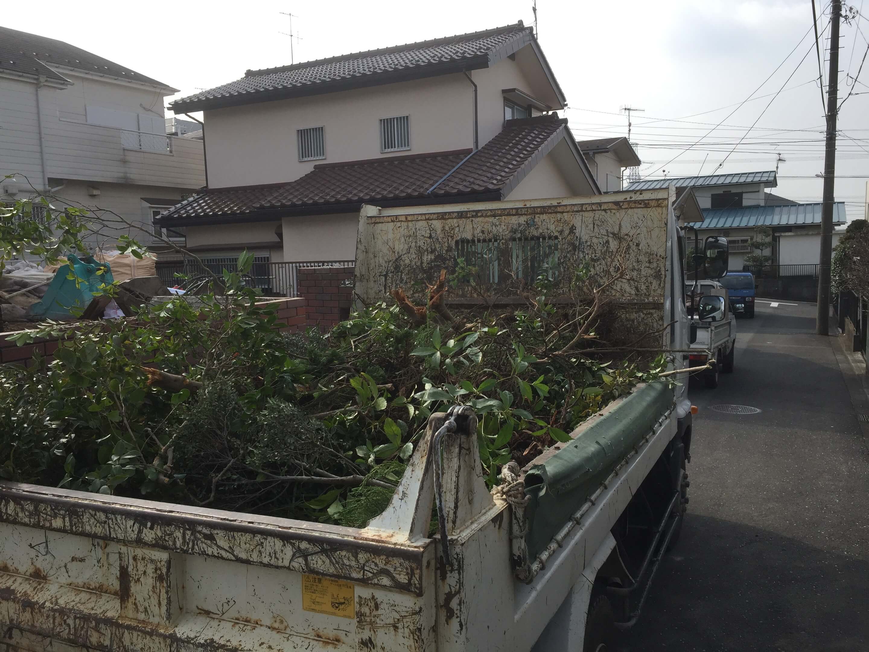 伐採した植木をトラックに積み込んでいる様子